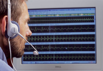 Un homme face a ordinateur avec un casque écoutant une synthèses (illustration) vocales