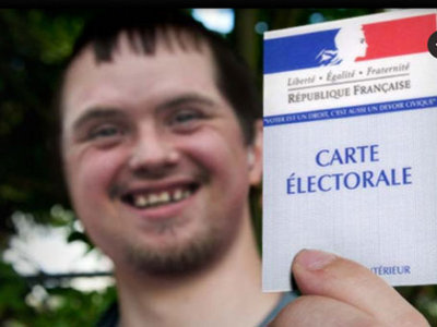 Un jeune garçon déficience mental tenant dans ma main sa carte d’électeur qu'il montre avec fierté !©unapei 