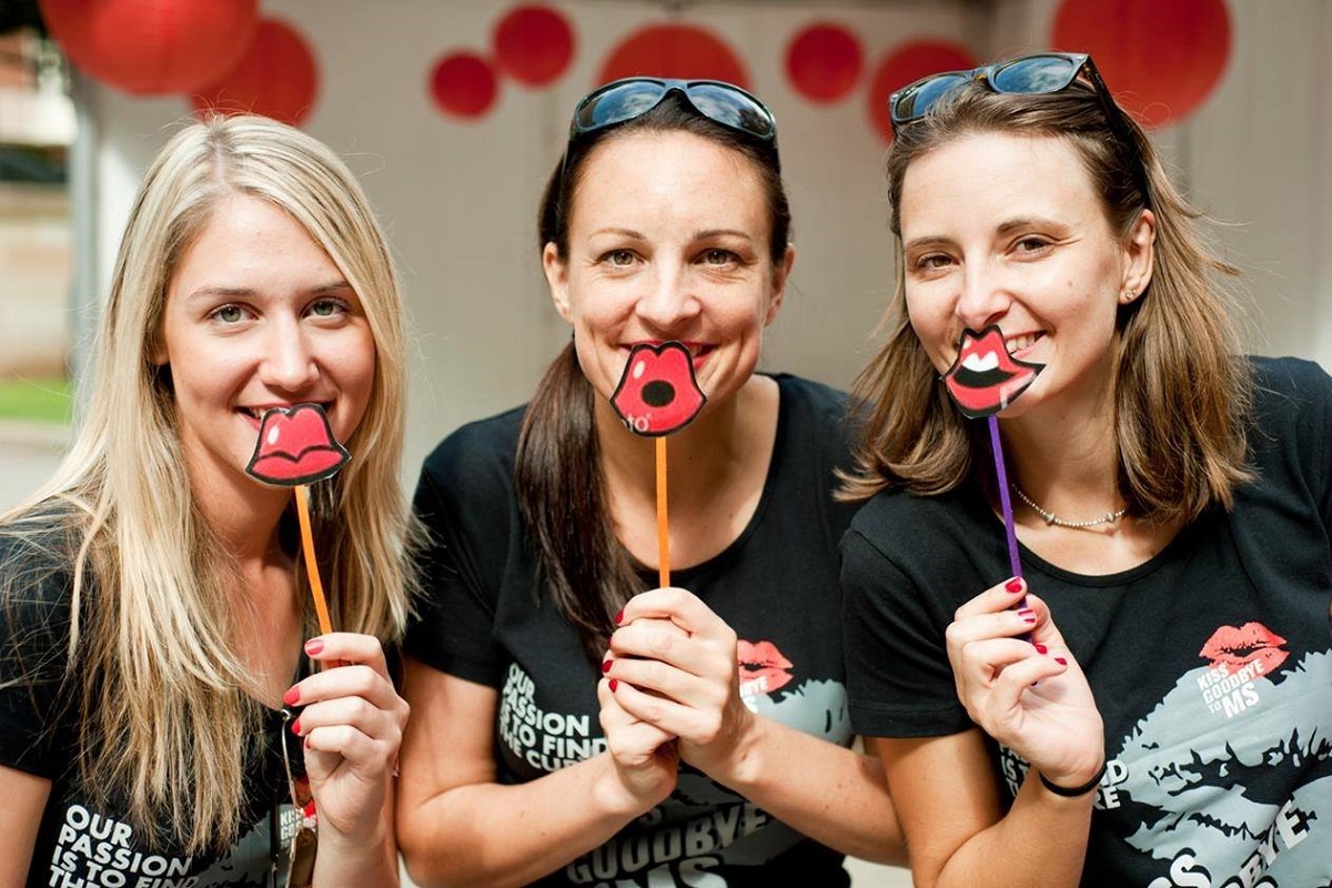 Trois femmes portant une levre rouge en carton en signe d adhesion pour la campagne 2016 Un baiser d_adieu a la SEP organise du 14 janvier au 14 fevrier 2016