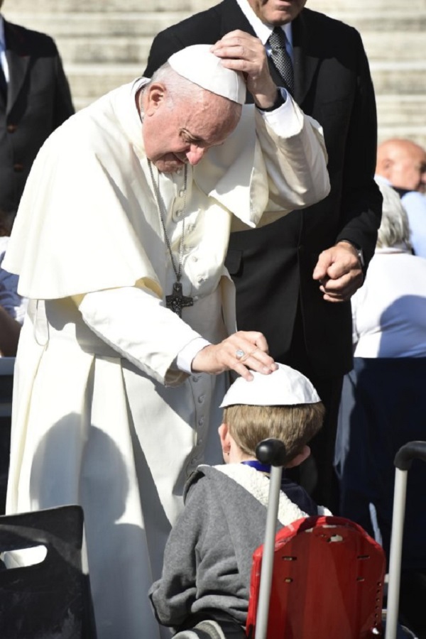 Le Pape François sur la Place Saint Pierre de Rome a la Cite du Vatican benissant un enfant handicape