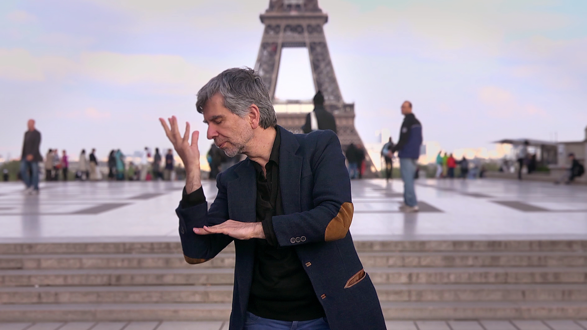 Photo extrait du film j avancerai vers toi avec les yeux d_un sourd. Un homme signant devant la Tour eiffel sur le Parvis des droits de l_homme a Paris