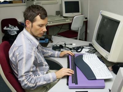 Thomas un jeune non voyant face a son ordinateur équipe d'un clavier braille