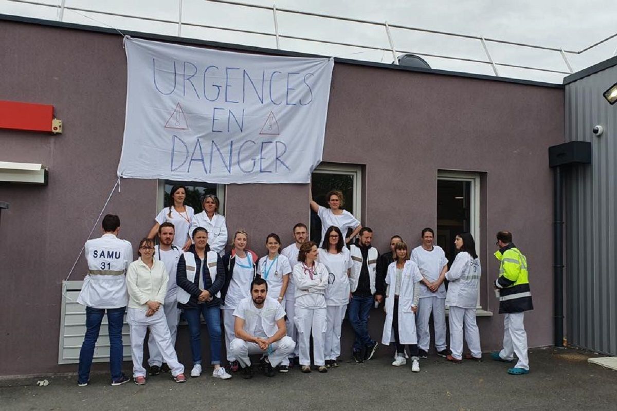 Des infirmiers et infirmières devant un hôpital avec marqué sur leurs vêtement gréve et leurs colères c7b73