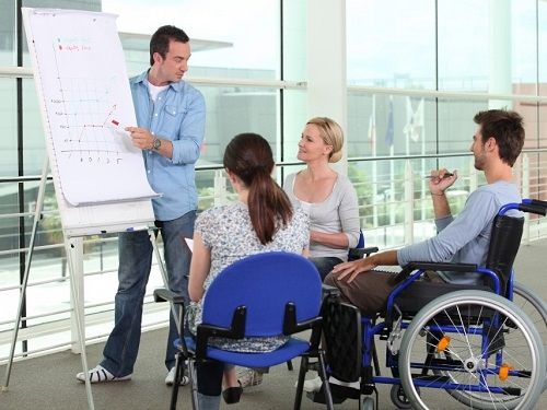 Un homme donnant une information sur l'économie a des étudiants notamment un a mobilité réduite. (Illustration)