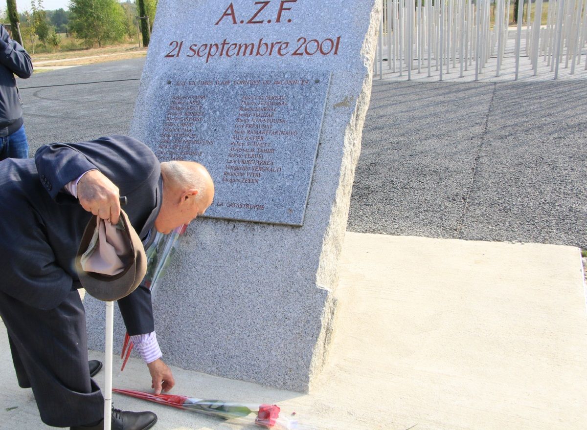 Un homme déposant une rose devant la stèle des victimes de l azf lors de la cérémonie à Toulouse 7fd04