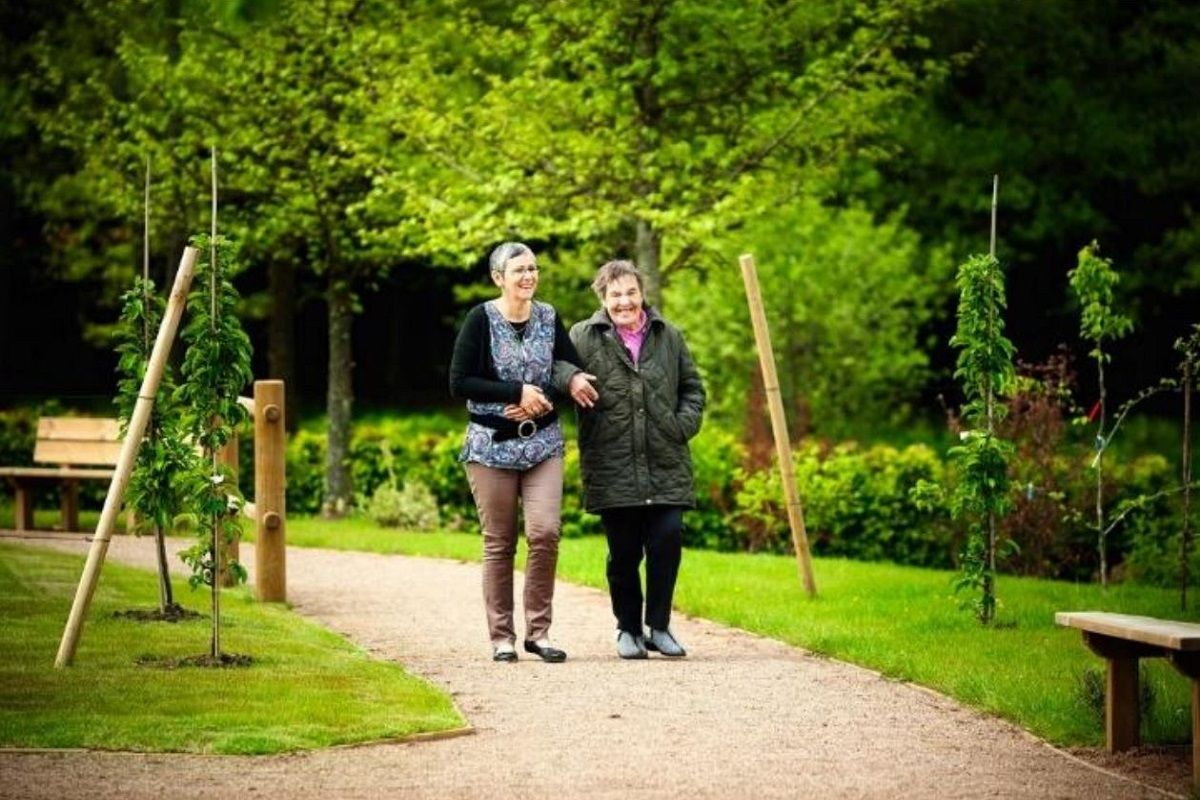 Un soignant et un malade se pronemant au sein du jardin Terramie