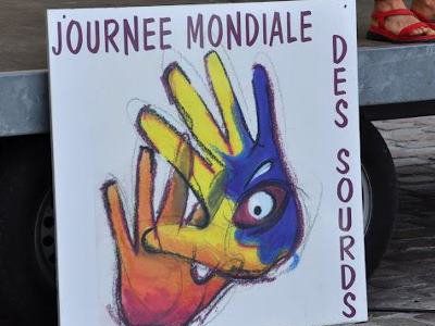 Un carton avec deux main dessiné et sur lequel il est écrit journée mondial des sourds