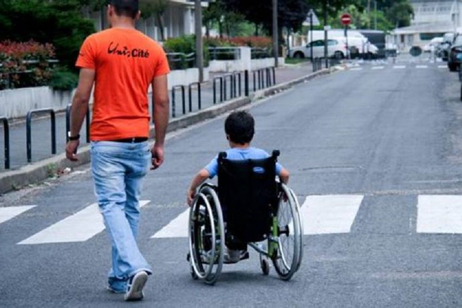 Un pere accompagnant son fils en fauteuil