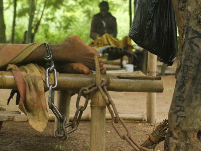 un homme au Ghana en situation de handicap mental attaché a un arbre