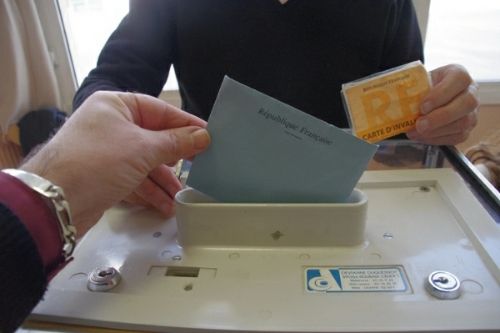 Une personnes en situiation de handicap en passe de mettre son bulletin dans l'urne dans un bureau de vote situé a Toulouse lors des élections présidentielles de mai 2012