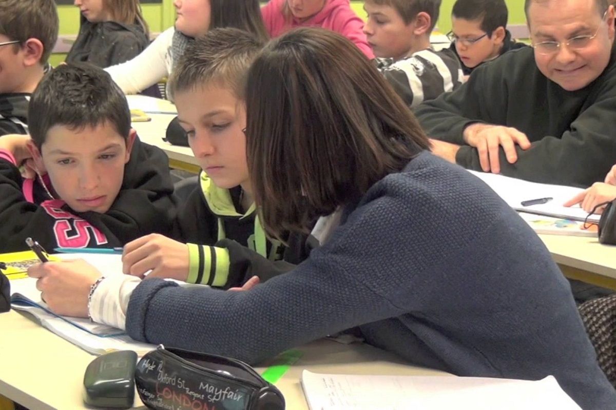 Une AVS en classe accompagnant un enfant en situation de handicap dans une ecole a Vatelot
