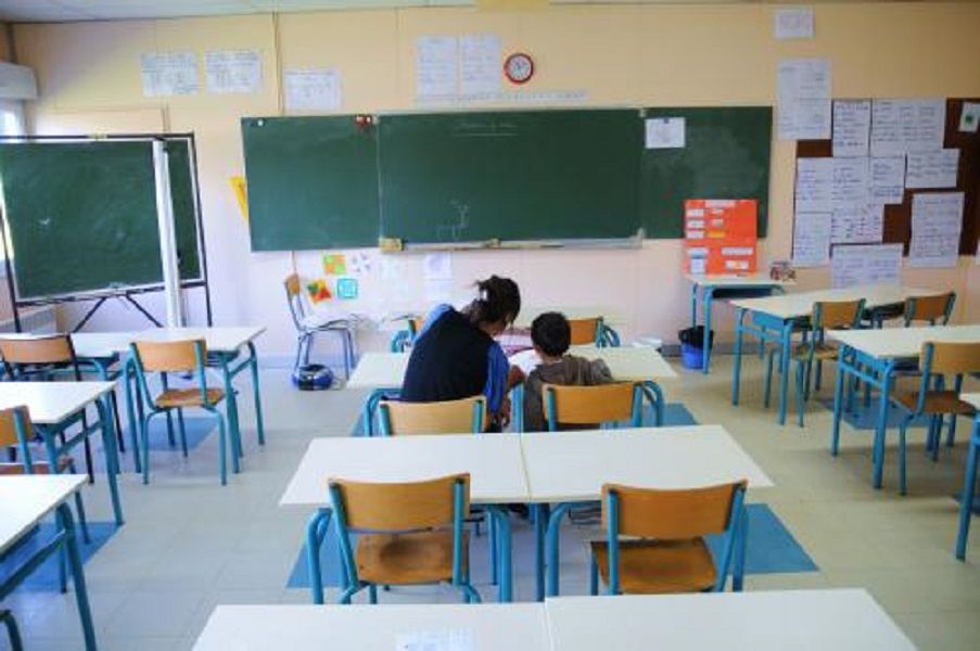 un enfant aupres d un avs dans une classe dans la banlieux parisienne